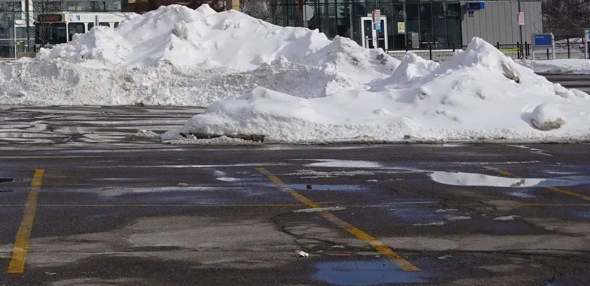 Plowed Oakville parking lot with painted bays and snow banked at its edge